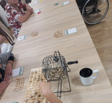Zdjęcia_nr_16_przedstawiają_stoły_z_rozłożonymi_kartami_i_żetonami_do_gry_w_Bingo.png