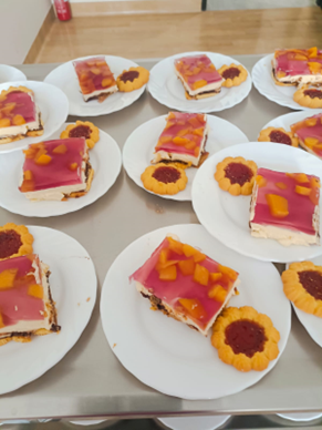 Zdjęcia_nr_24_przedstawiają_desery_naleśniki_z_owocami_banany_w_sosie_z_wafelkami_szarlotka_i_ciasto_z_galaretką-_efekty_pracy_seniorów_podczas_treningów_z_samoobsługi__kulinoterapii.png