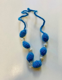 Zdjęcie_nr_1_przedstawia_niebieski_naszyjnik_zrobiony_na_szydełku_przeplatany_perełkami.png