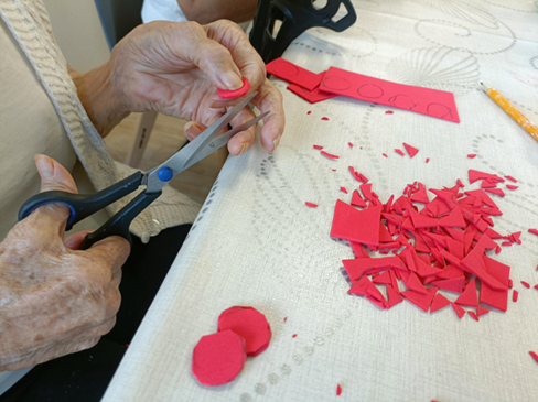 Zdjęcie_nr_7_przedstawia_zajęcia_z_arteterapii_podczas_których_seniorzy_wycinali_elementy_do_tworzenia_breloków.png
