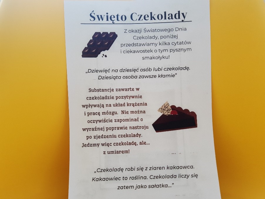 Na białej kartce z nadrukiem kawałków czekolady, napis ŚWIĘTO CZEKOLADY oraz kilka cytatów i ciekawostek o czekoladzie