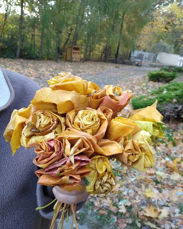 Na zdjęciu widać bukiet kwiatów zrobiony z jesiennych liści